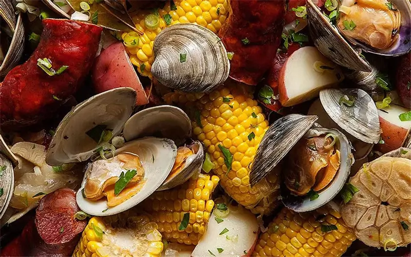 Seafood boil with clams, corn, sausage, potatoes, and garlic